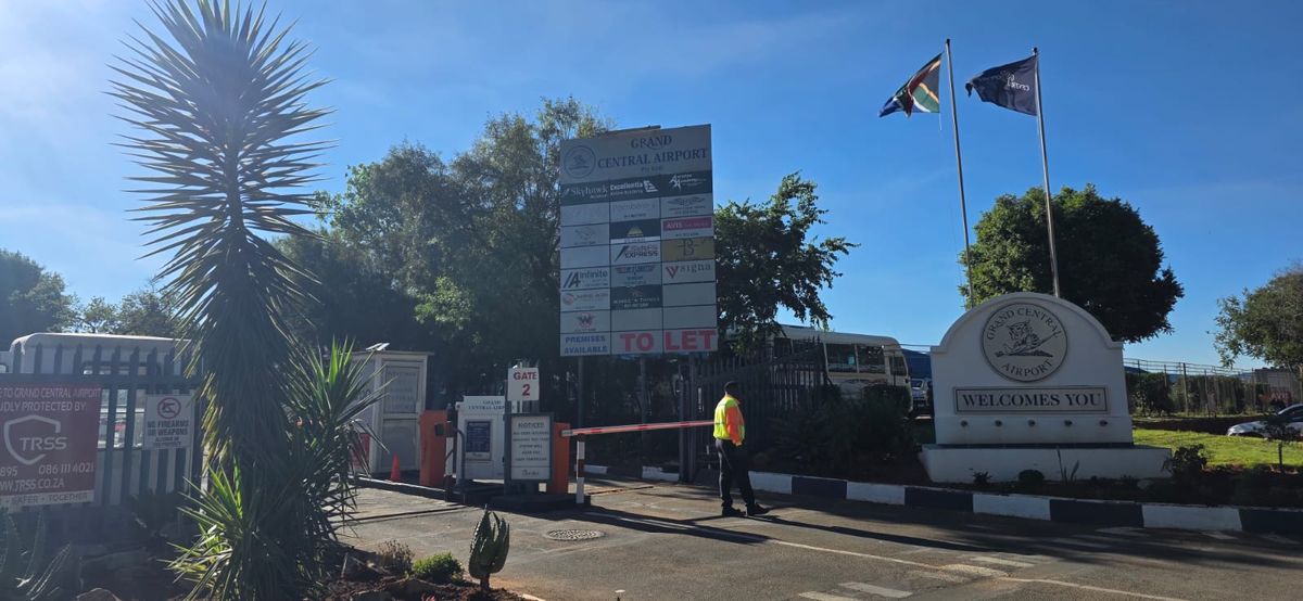 The main gate into Grand Central Airport, with the boom gate and the sign board listing the businesses inside